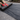 Person rolling out black landscape fabric on a gravel surface