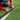 Person installing a strip of black material on artificial grass