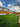 Backyard with artificial grass, wooden fence, and clear sky
